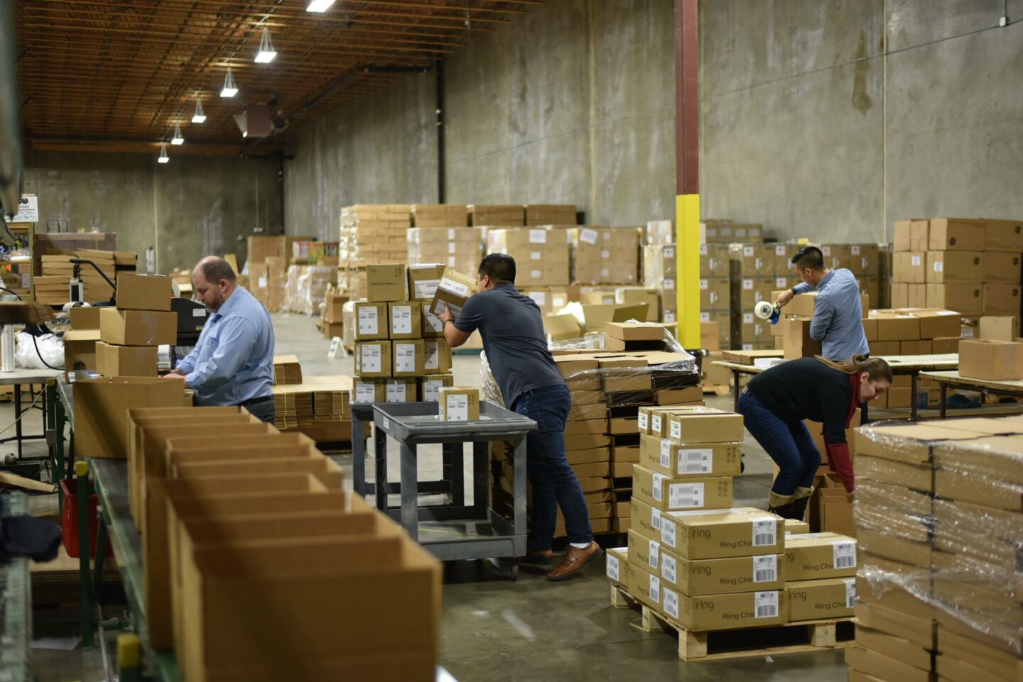 People moving boxes in warehouse